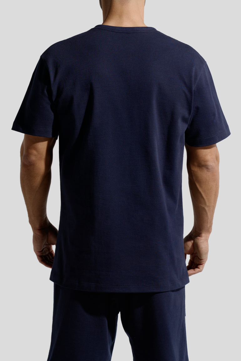 image of organic cotton T-shirt in Marino Blue back view on male model by Bas Bains