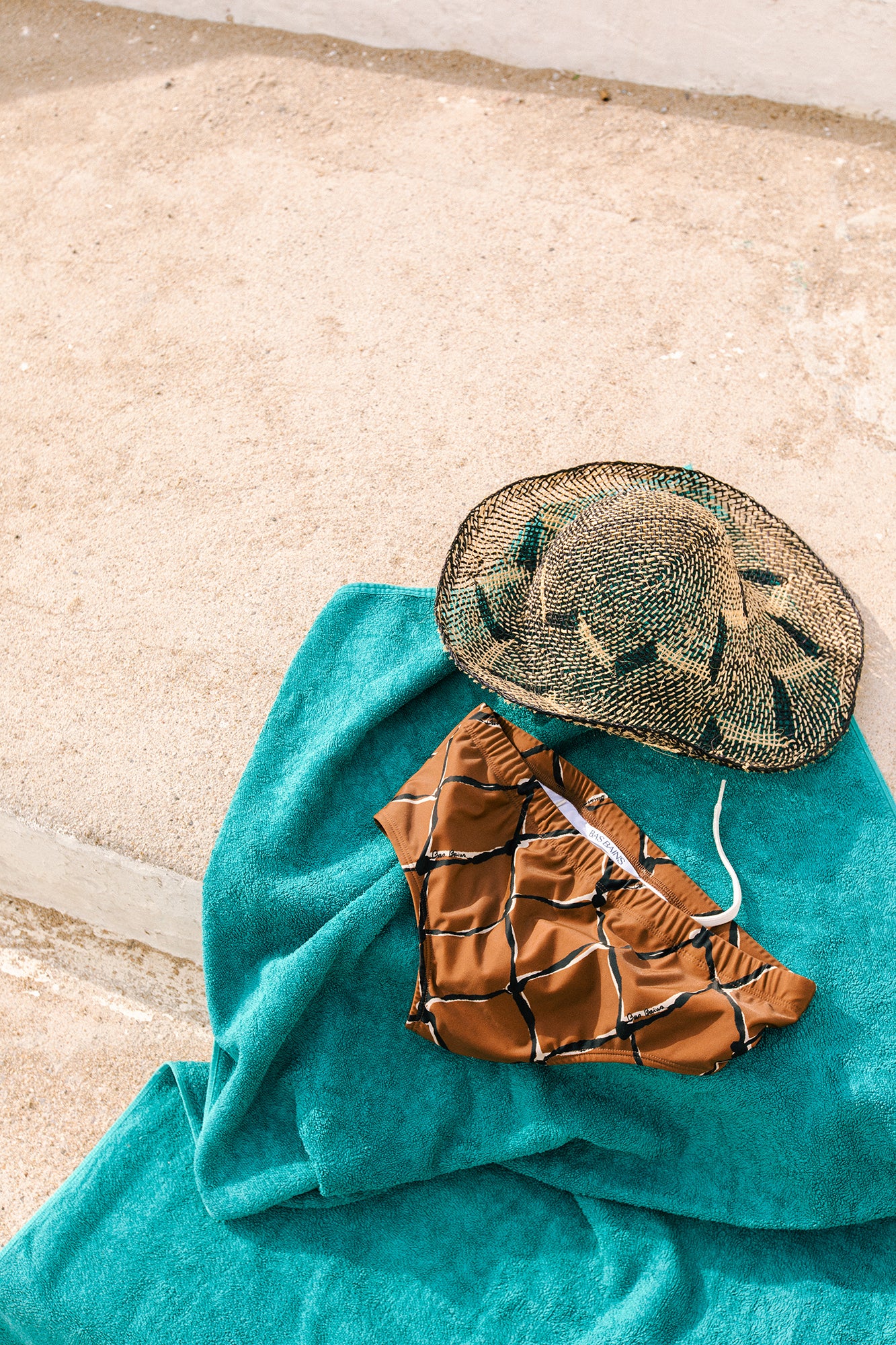 Sunga Pescador, straw hat and turquoise towel still life by Bas Bains